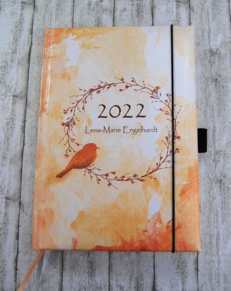 personalisierter Buchkalender mit Kranz und Vogel in Orange und Gelb